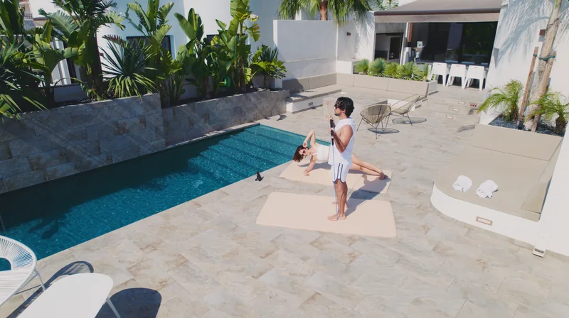 Sam utilise une bande de résistance et Charline réalise un gainage au bord de la piscine.